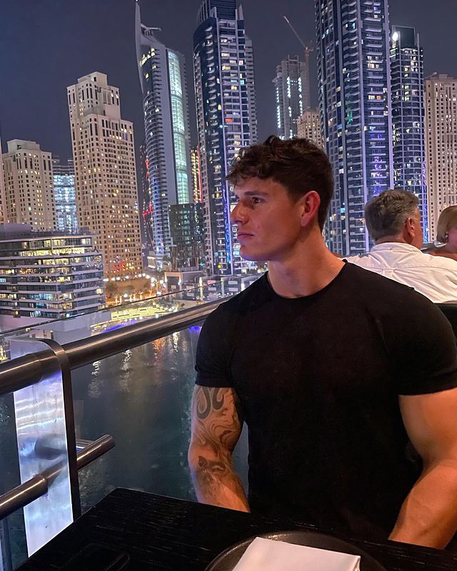Luke in a black T-shirt above a city skyline (Instagram post)