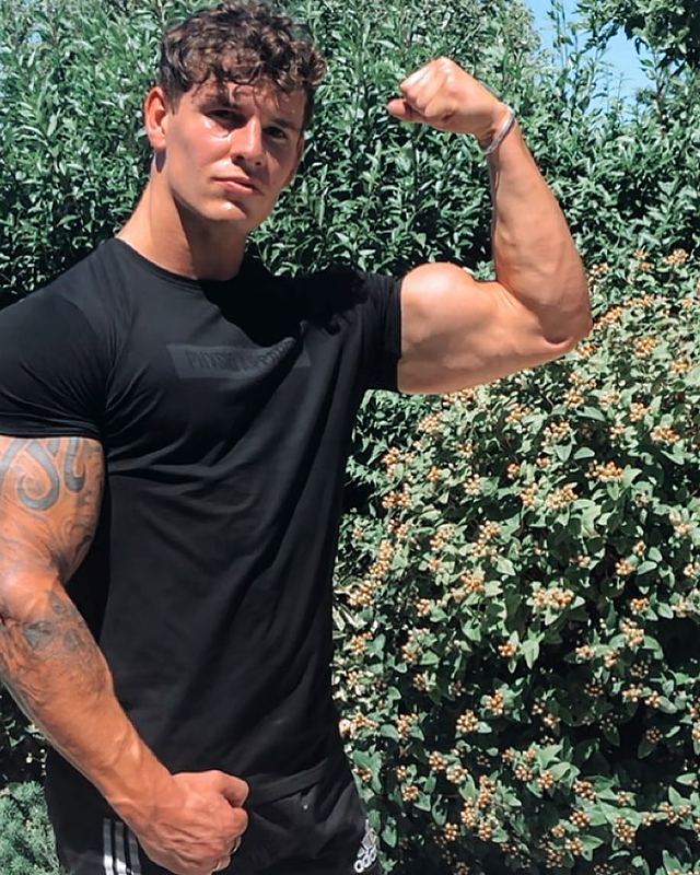 Luke flexing in a black T-shirt (Instagram post)